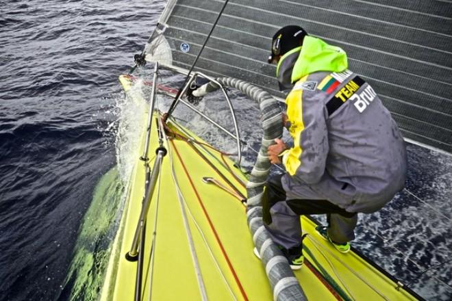 Team Brunel - Rokas Milevicius sorts out the furled sail after a sail change - Volvo Ocean Race 2014-15 © Stefan Coppers/Team Brunel